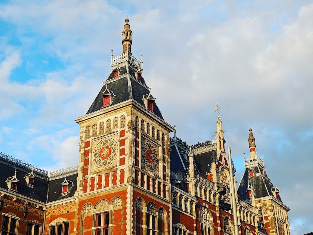 Rijk versierde historische stationsgevel onder een bewolkte hemel