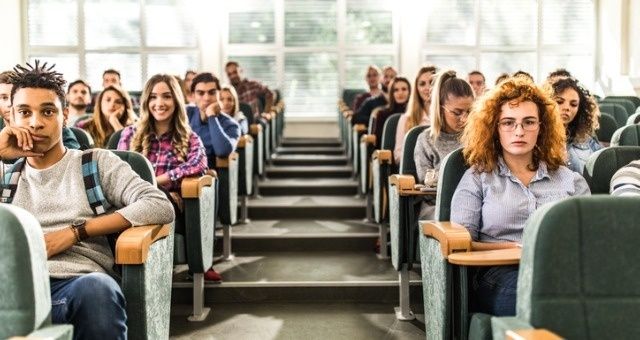Studenten zitten in rijen in een collegezaal tijdens een les